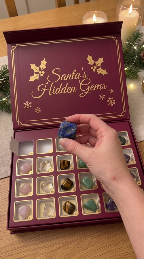 Santa's Hidden Gems advent calendar open with a gemstone held up
